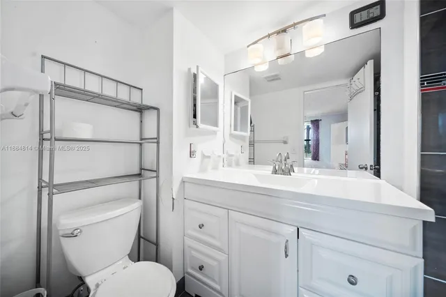 a bathroom with a toilet a sink and mirror