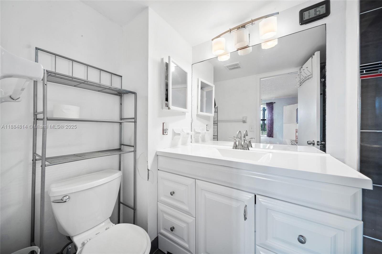 9258 Northwest 1st Street, Unit 206 Pembroke Pines, FL 33024 - Photo 14 of 22 a bathroom with a toilet a sink and mirror