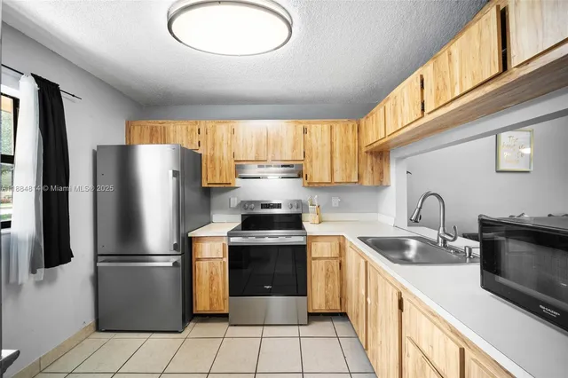 a kitchen with stainless steel appliances granite countertop a refrigerator sink and stove