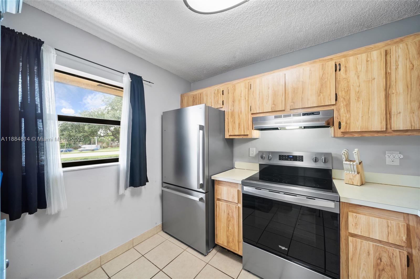 9258 Northwest 1st Street, Unit 206 Pembroke Pines, FL 33024 - Photo 5 of 22 a kitchen with appliances cabinets and a refrigerator