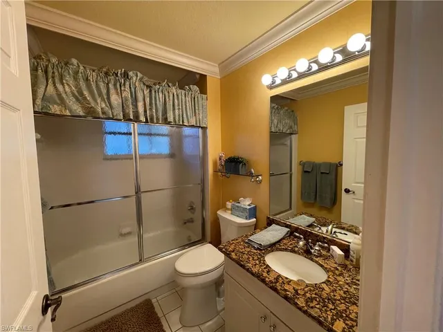 a bathroom with a granite countertop sink toilet mirror and a shower