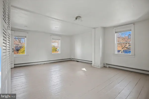 a view of a closet area with wooden floor