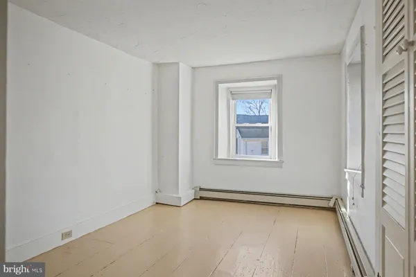 an empty room with cabinet and mirrors