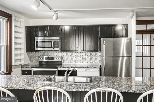 a kitchen with refrigerator cabinets and large window