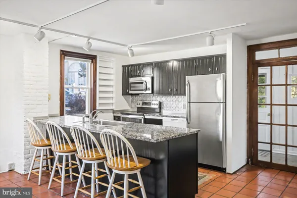 a dining room with stainless steel appliances a table and chairs