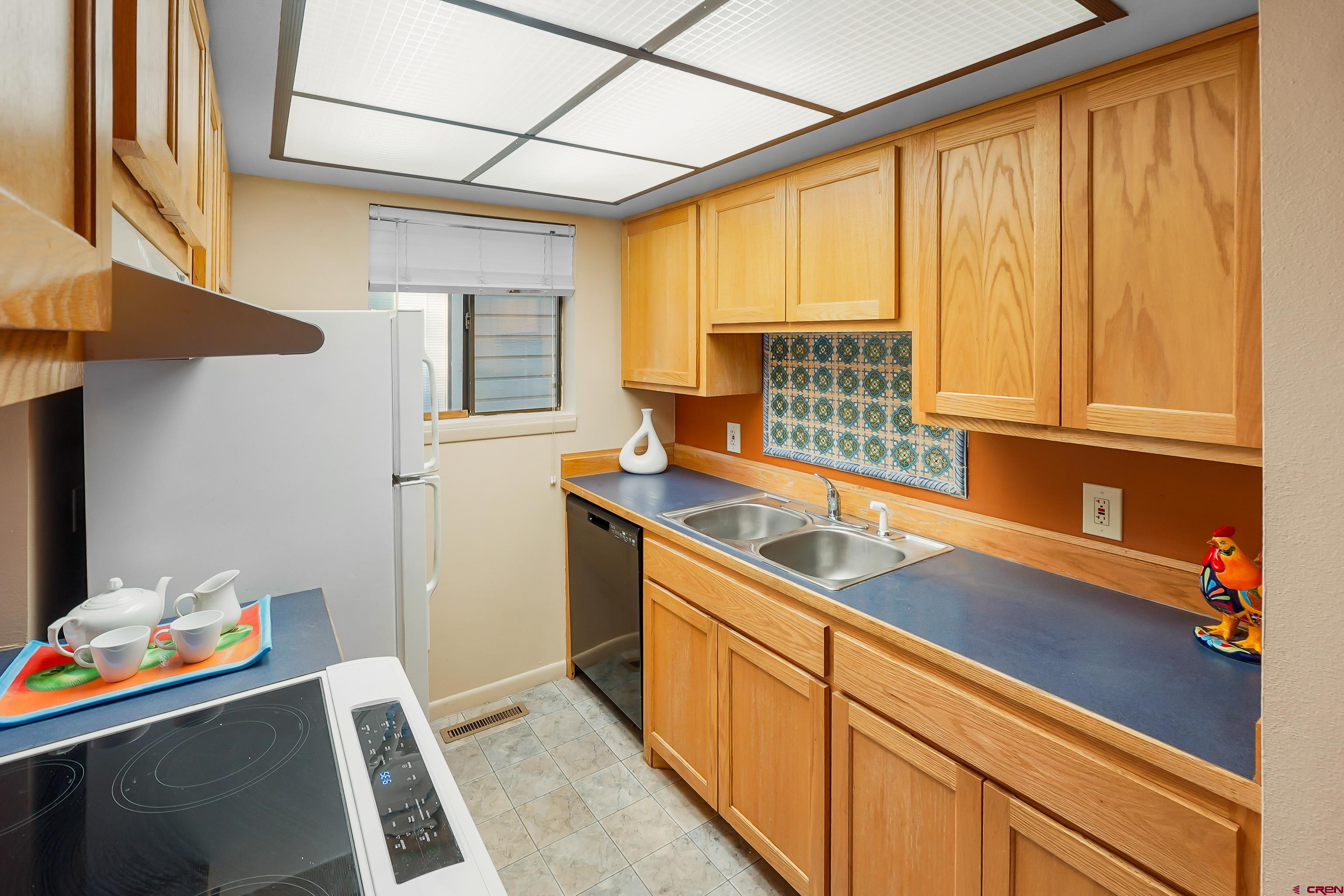 1200 Florida Road, Unit 7 Durango, CO 81301 - Photo 12 of 26 a kitchen with stainless steel appliances granite countertop a sink dishwasher stove and refrigerator with wooden floor