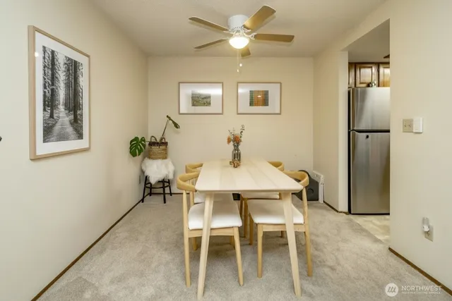 a view of a dining room with furniture and a chandelier fan