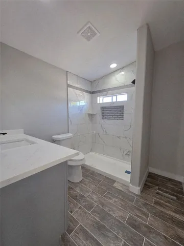 a bathroom with a sink a toilet and shower