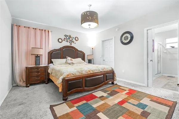 a bedroom with a bed and a lamp on dresser
