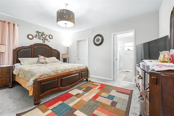 a bedroom with a bed and a lamp on dresser