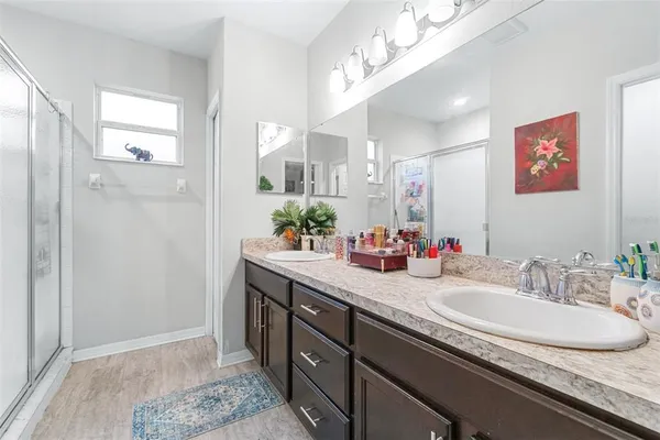 a bathroom with a granite countertop sink a mirror and a shower