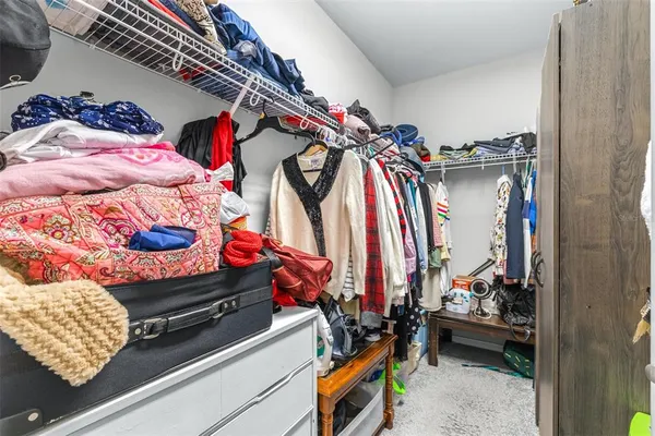 a view of walk in closet with clothes and shoes