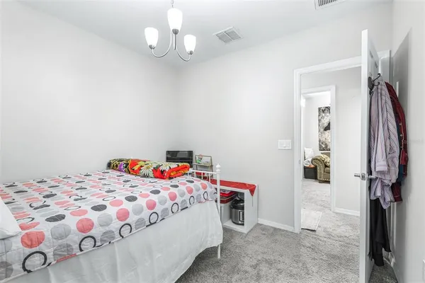 a bedroom with a bed and a chandelier