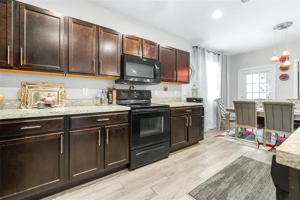 a kitchen with stainless steel appliances granite countertop a stove sink microwave and refrigerator