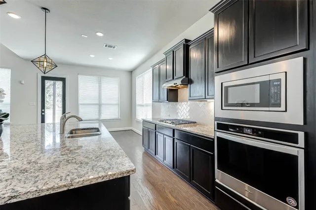 a kitchen with stainless steel appliances granite countertop a sink stove and oven