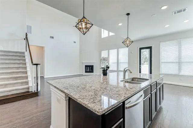 a kitchen with granite countertop kitchen island a sink appliances and a counter top space