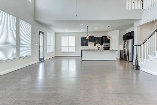 a view of a living room and kitchen with furniture wooden floor and window