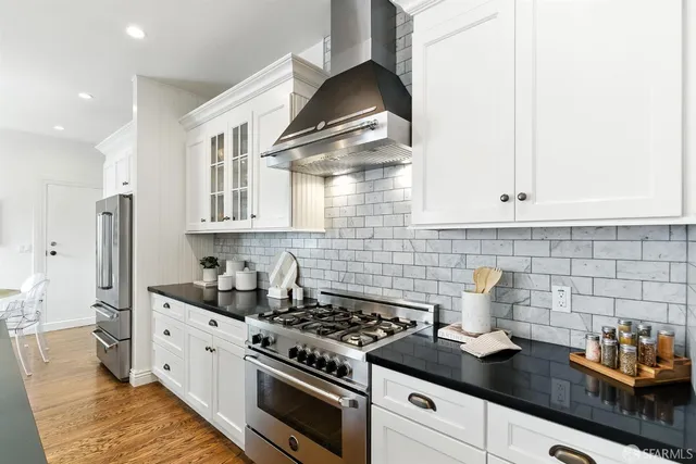 a kitchen with stainless steel appliances a stove a sink and cabinets