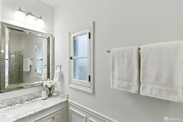 a bathroom with a granite countertop sink and a mirror