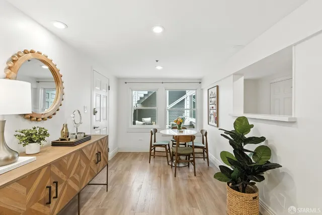 a living room with furniture flowerpot and wooden floor