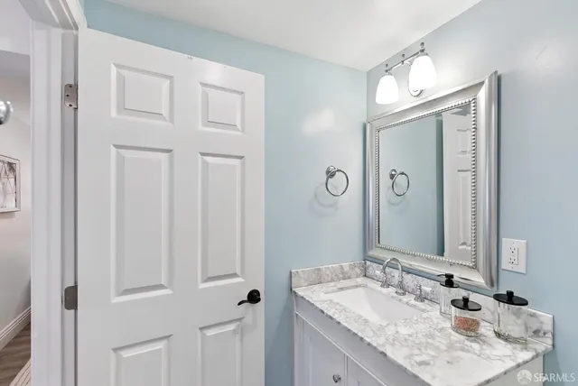 a bathroom with a granite countertop sink and a mirror