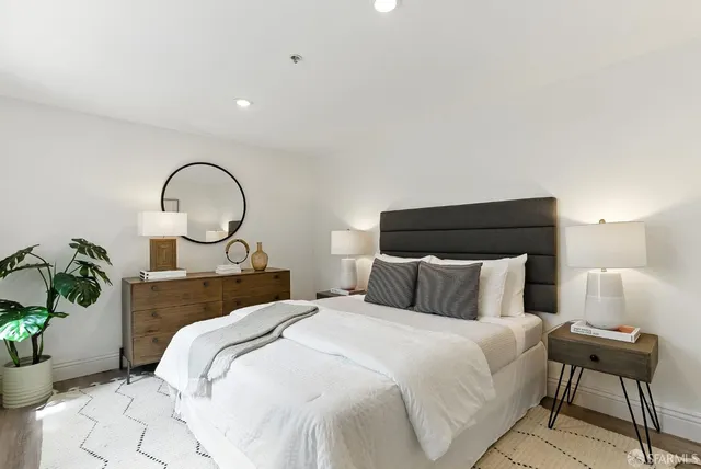 a bedroom with a bed and a potted plant