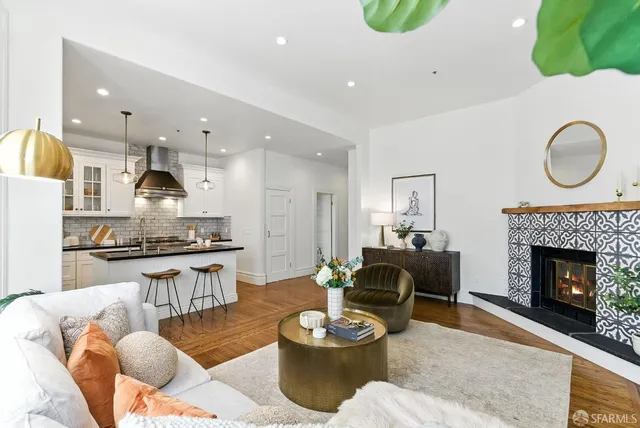 a living room with furniture a fireplace and a kitchen