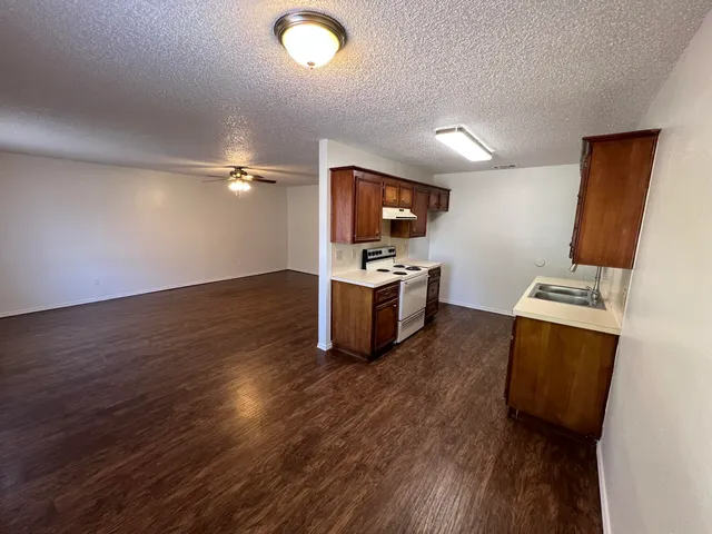 a kitchen with wooden floor and stainless steel appliances