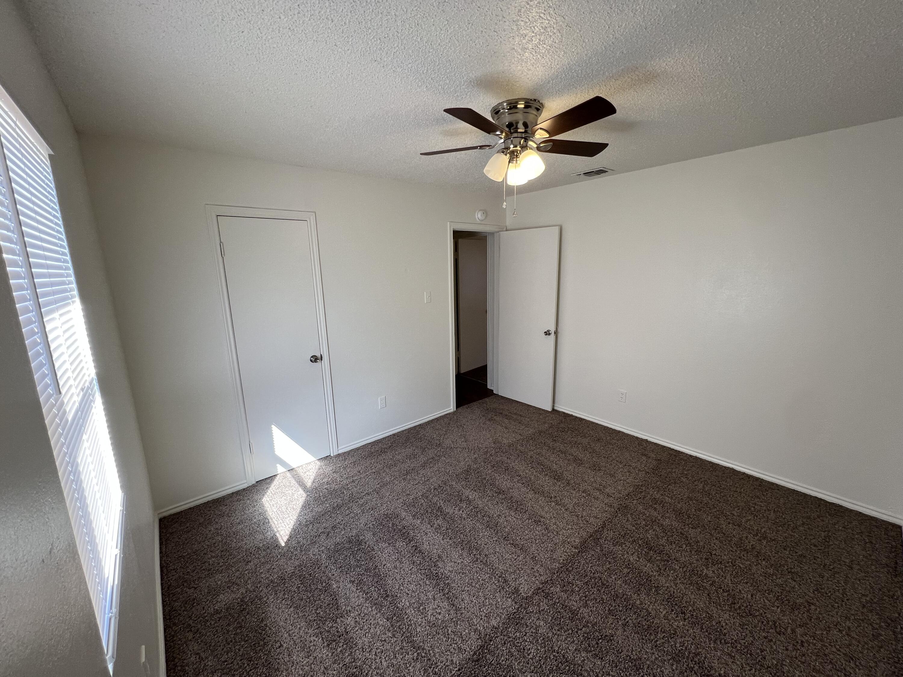 2409 88th Street Lubbock, TX 79423 - Photo 5 of 7 wooden floor in an empty room with a window