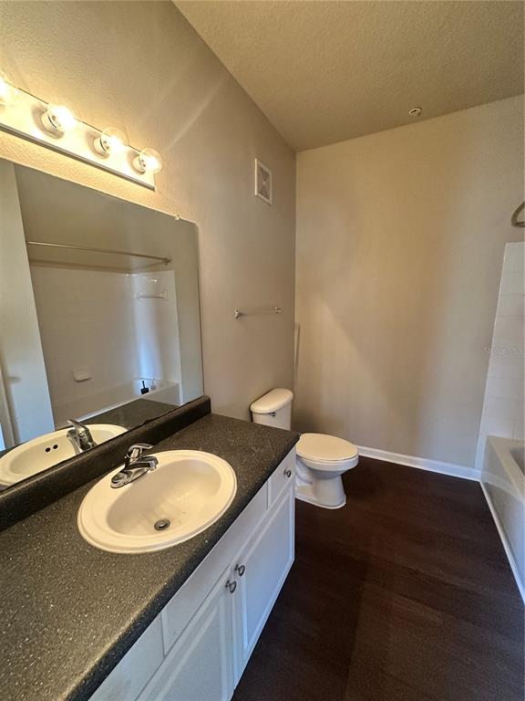 8849 Villa View Circle, Unit 306 Orlando, FL 32821 - Photo 11 of 15 a bathroom with a double vanity sink toilet and a mirror
