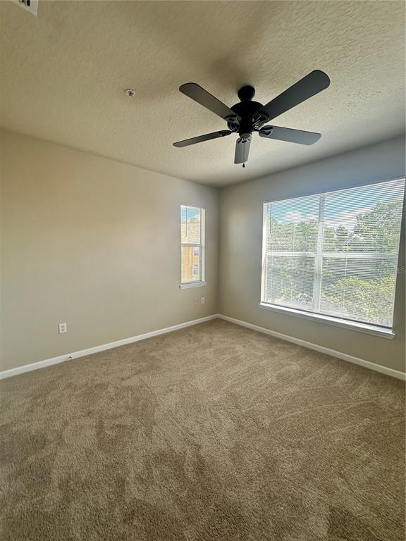 8849 Villa View Circle, Unit 306 Orlando, FL 32821 - Photo 12 of 15 an empty room with windows and fan