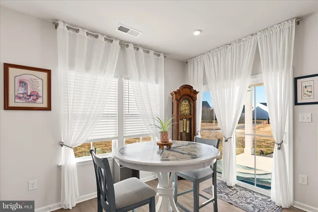 a kitchen with stainless steel appliances a refrigerator a stove a dining table and chairs