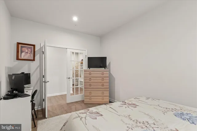 a view of a bedroom with wooden floor and flat screen tv