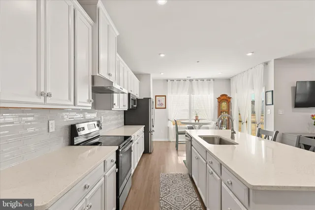 a kitchen that has a lot of cabinets a sink and appliances in it