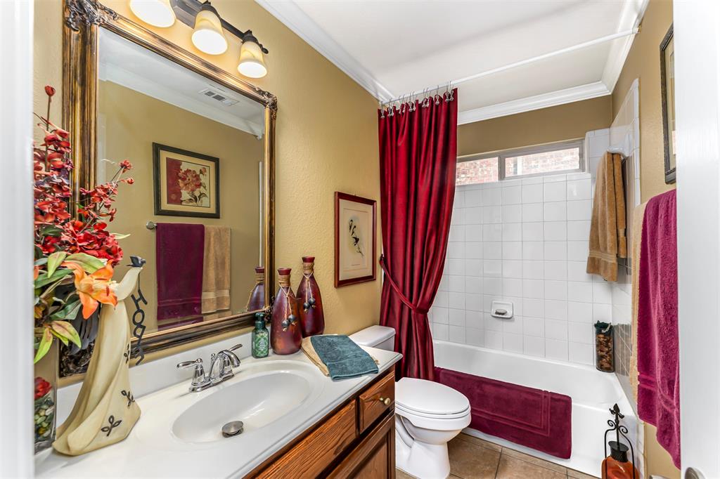 1601 Meadow Ranch Road McKinney, TX 75071 - Photo 18 of 31 Bathroom featuring a wood-finish vanity, white countertop with an integrated sink, chrome faucet, and a large framed mirror