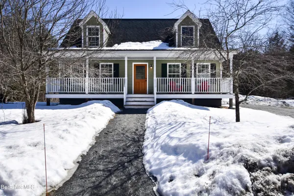 a front view of a house with a yard covered in snow