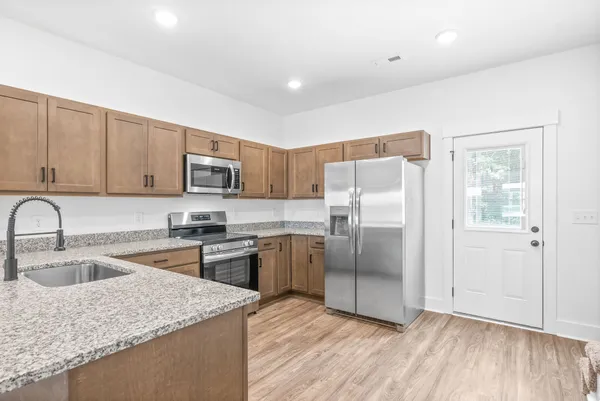 a close view of a refrigerator in kitchen and an empty room