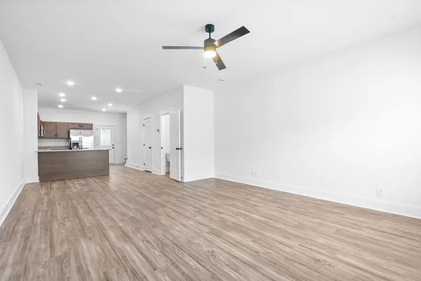 a kitchen with stainless steel appliances granite countertop a refrigerator a sink dishwasher a stove with wooden cabinets and floors