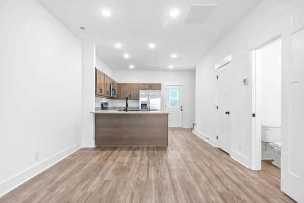 a kitchen with a sink cabinets and wooden floor