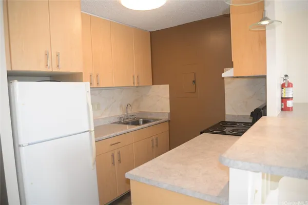 a kitchen with a sink a refrigerator and cabinets