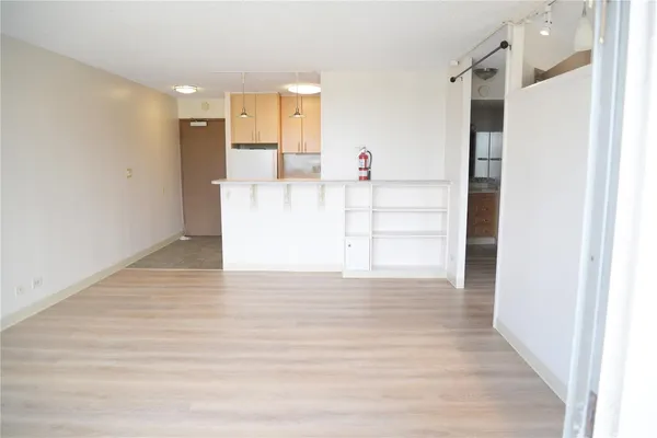 a view of empty room with wooden floor
