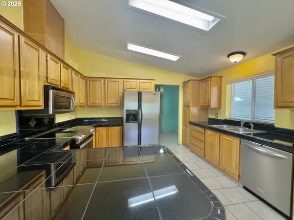 a kitchen with stainless steel appliances a stove refrigerator sink and microwave
