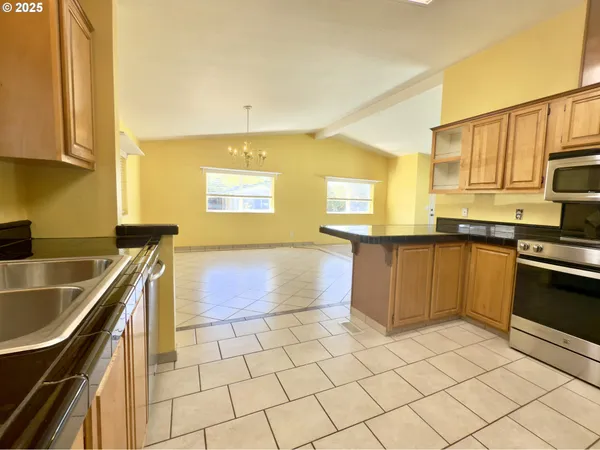 a kitchen with stainless steel appliances granite countertop a sink and a stove