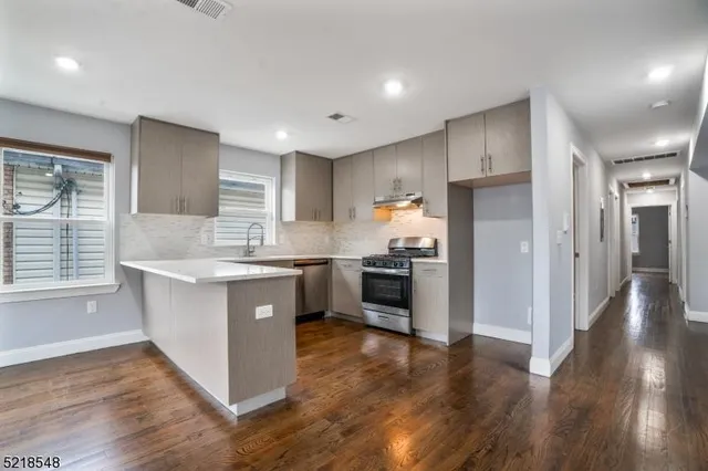 a kitchen with stainless steel appliances sink refrigerator and microwave