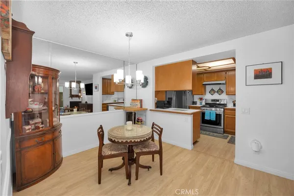 a kitchen with a dining table chairs stainless steel appliances and cabinets