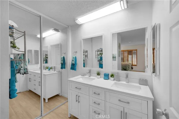 a bathroom with a double vanity sink mirror and bathtub