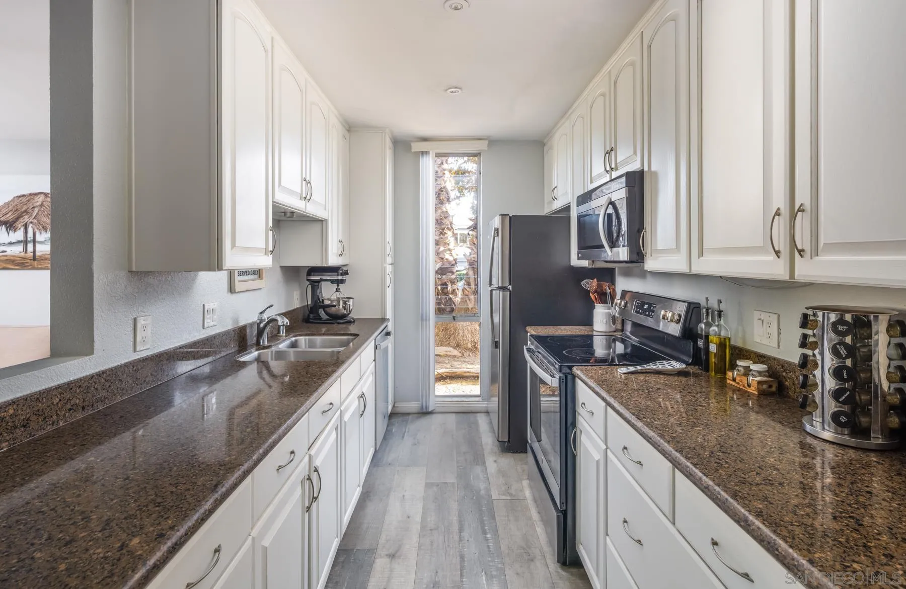 6333 La Jolla Boulevard, Unit 170 La Jolla, CA 92037 - Photo 3 of 18 a kitchen with granite countertop a sink a counter space appliances and cabinets