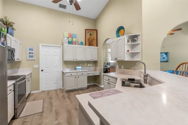 a living room with kitchen island a sink stove and refrigerator