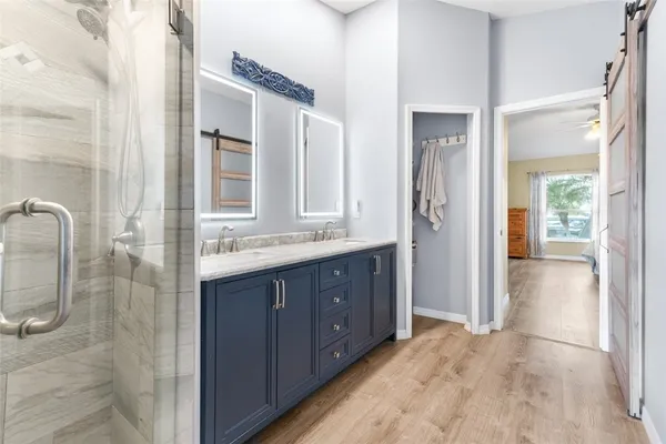 a bathroom with a double vanity sink mirror and shower