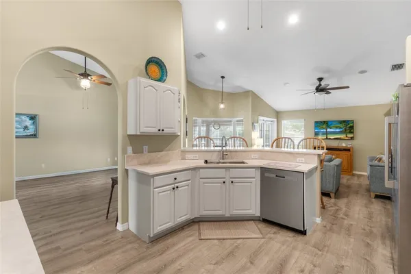 a kitchen with a sink cabinets and wooden floor